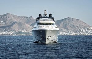 Monte Carlo Yachts MCY 96 Monte Carlo Yachts MCY 96, 2020 model, cruising in scenic coastal waters with mountainous backdrop.