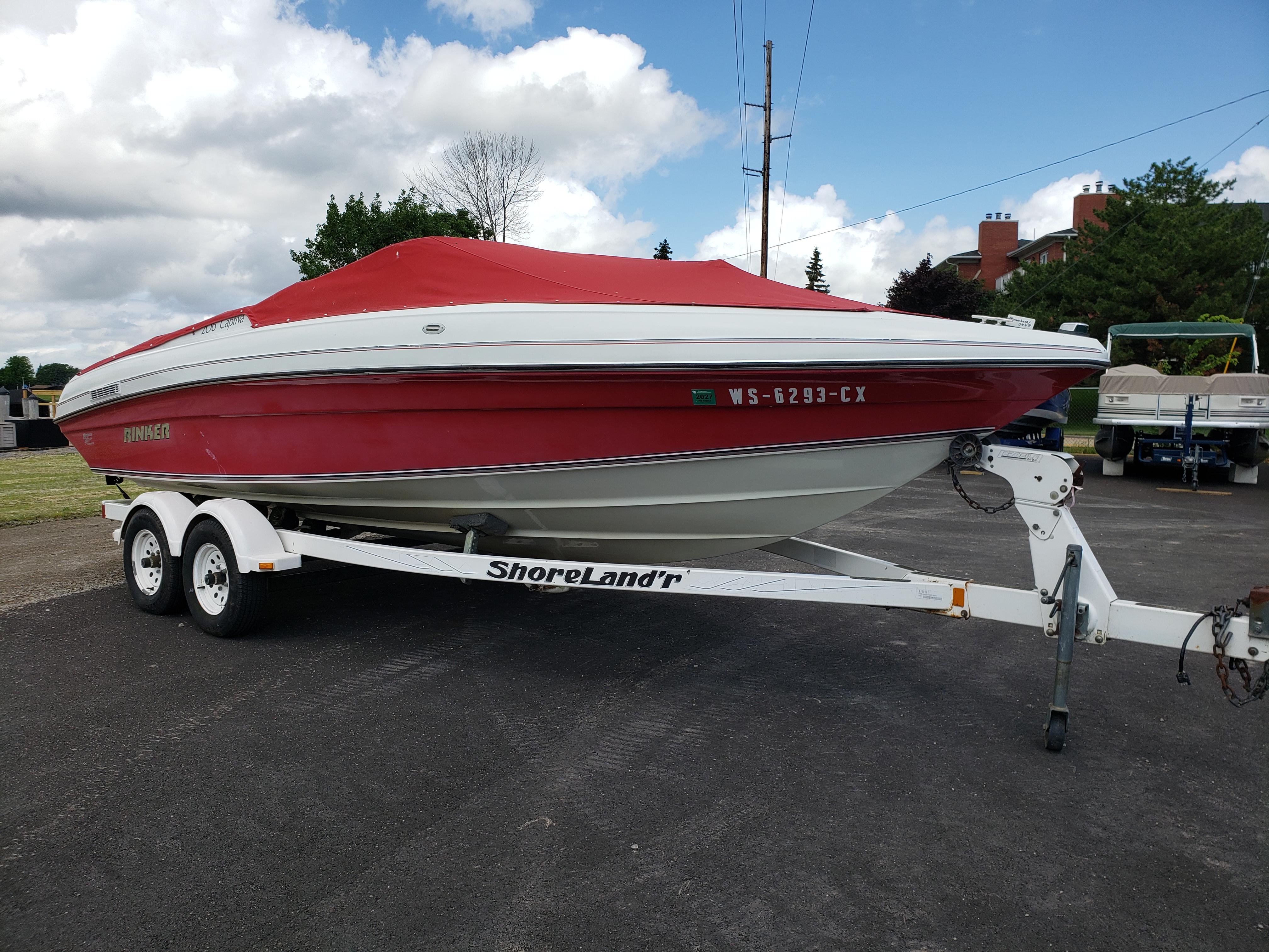Rinker 206 Captiva Red 1993 Rinker 206 Captiva boat on trailer, parked outdoors under cloudy sky.
