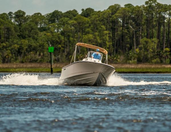 Edgewater 188CC 2025 Edgewater 188CC boat cruising on a scenic waterway with lush greenery.