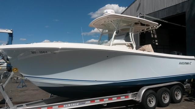 Sailfish 270 CC 2015 Sailfish 270 CC boat on trailer, parked outdoors under blue sky.