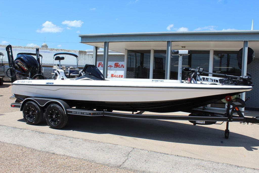 Skeeter ZXE21 2026 Skeeter ZXE21 boat on trailer outside dealership under clear blue sky.