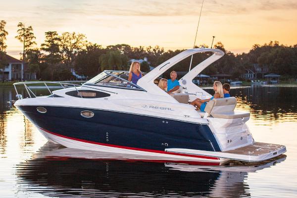 Regal 30 Express Manufacturer Provided Image: 2017 Regal 30 Express boat on a serene lake at sunset with people onboard.