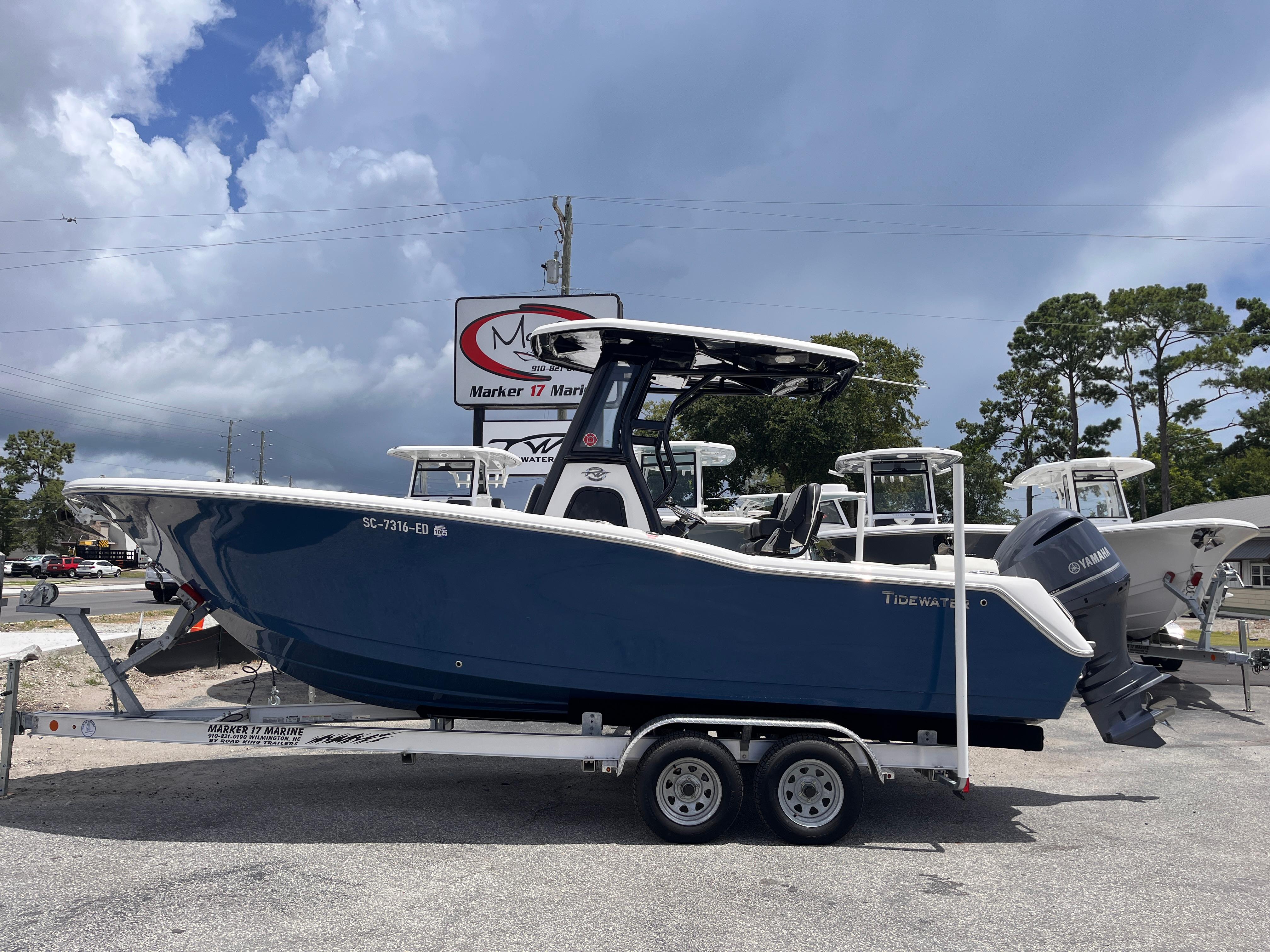 Tidewater 232 LXF 2023 Tidewater 232 LXF boat on trailer, displayed outdoors under cloudy sky.