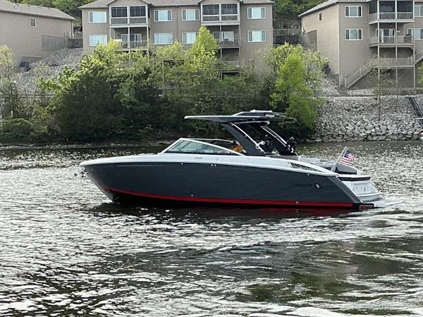 Cobalt R33 Surf 2025 Cobalt R33 Surf boat on a lake with houses in the background.