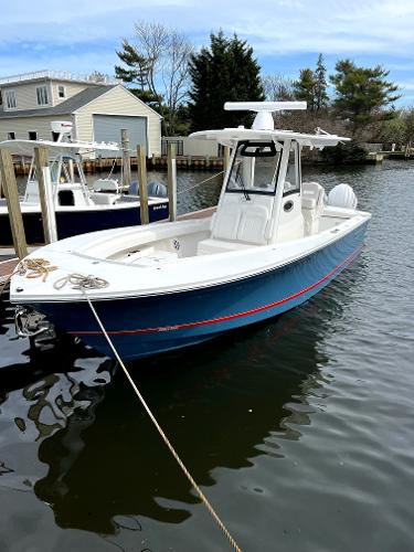 Regulator 28 2023 Regulator 28 boat docked in a marina, featuring a sleek blue hull and modern design.