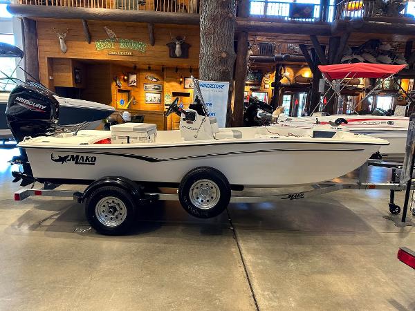Mako Pro Skiff 15 CC 2025 Mako Pro Skiff 15 CC boat displayed indoors on a trailer.