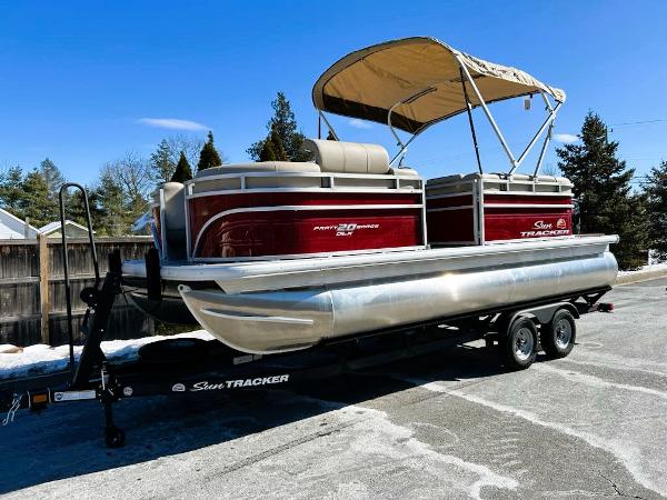 Sun Tracker Party Barge 20 DLX 2025 Sun Tracker Party Barge 20 DLX pontoon boat on trailer, parked outdoors.