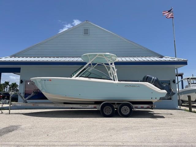 Cobia 240 Dual Console 2019 Cobia 240 Dual Console boat on trailer, parked outside a building with an American flag.