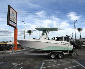 Wellcraft 223 Fisherman 2025 Wellcraft 223 Fisherman boat on trailer at dealership, clear sky background.