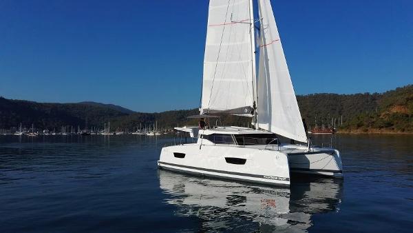 Fountaine Pajot Isla 40 2022 Fountaine Pajot Isla 40 catamaran sailing on calm waters with scenic background.