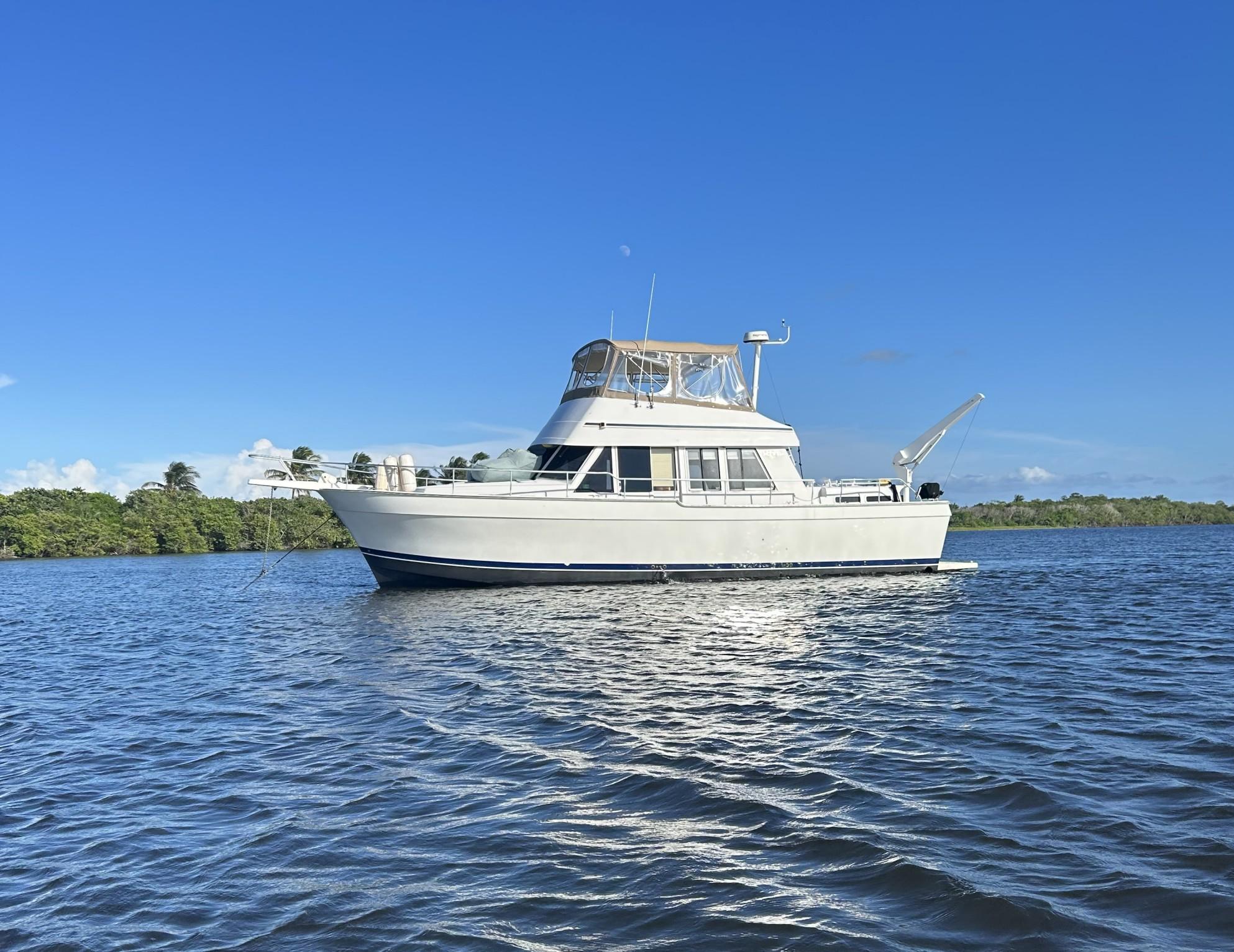 Mainship 430 Trawler 1999 Mainship 430 Trawler on calm water under clear blue sky.