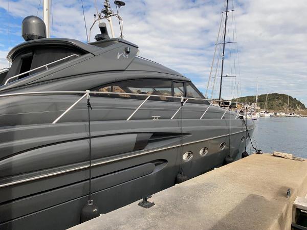 Princess V65 Luxury 2003 Princess V65 yacht docked at marina under cloudy sky.