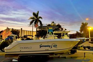 Robalo R260 Center Console 2004 Robalo R260 Center Console boat at sunset with palm trees and American flag.