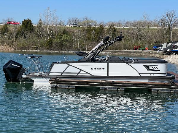 Crest Caribbean LX 230 SLRC 2025 Crest Caribbean LX 230 SLRC pontoon boat docked on a serene lake.