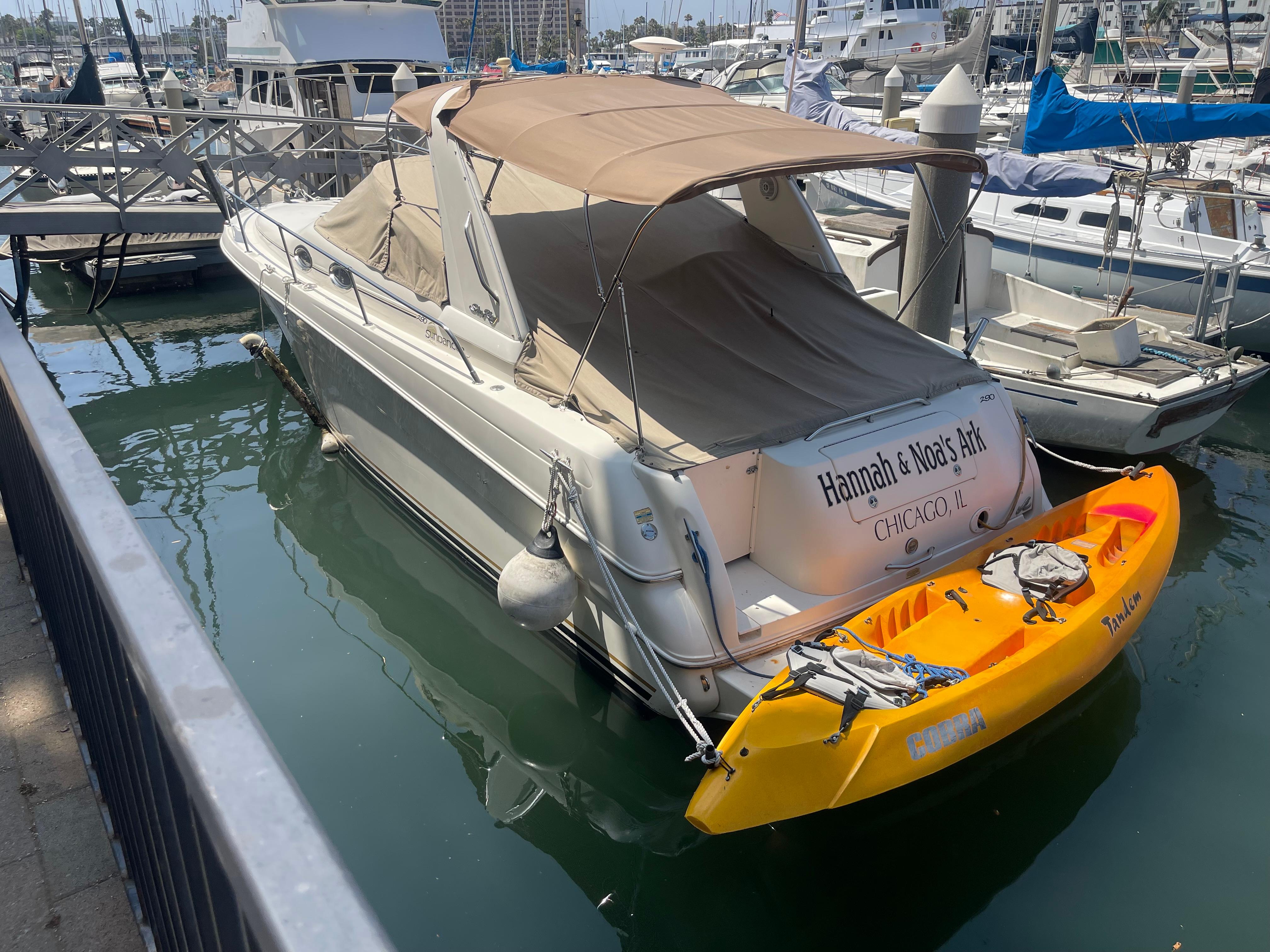 Sea Ray Express Cruiser 2000 Sea Ray Express boat docked with a yellow kayak attached, in a marina setting.