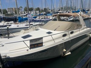 Sea Ray 290 Sundancer 2000 Sea Ray Express boat docked at marina with contact number displayed.