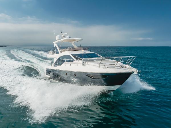 Azimut 50 2020 Azimut 50 yacht cruising on open sea, creating waves under clear blue sky.