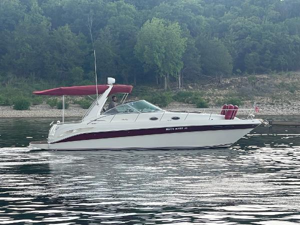 Sea Ray 340 Sundancer 2001 Sea Ray 340 Sundancer boat on calm water with forested shoreline.