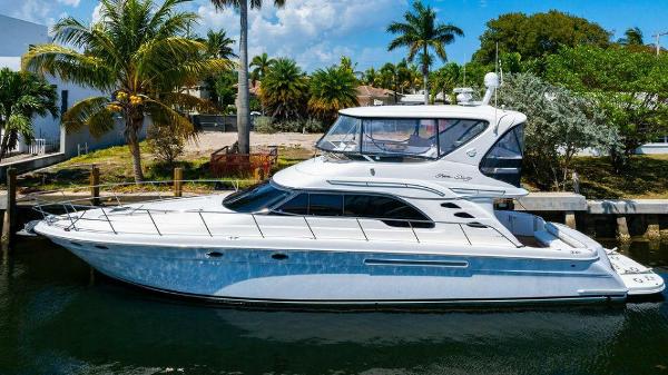 Sea Ray 560 Sedan Bridge 1999 Sea Ray 56 Sedan Bridge yacht docked by palm trees and waterfront homes.