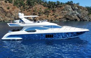 Azimut 70 Luxury 2010 Azimut 70 yacht cruising on clear blue waters near rocky coastline.