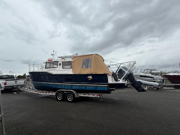 Ranger Tugs R-27 2020 Ranger Tugs R-27 boat on trailer under cloudy sky.