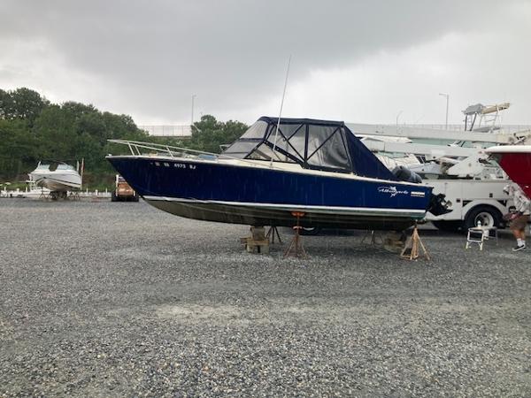Albemarle 24 1982 Albemarle 24 boat on gravel lot under cloudy sky.