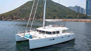 Lagoon 560 S2 2015 Lagoon 560 S2 catamaran sailing near a scenic coastal landscape.