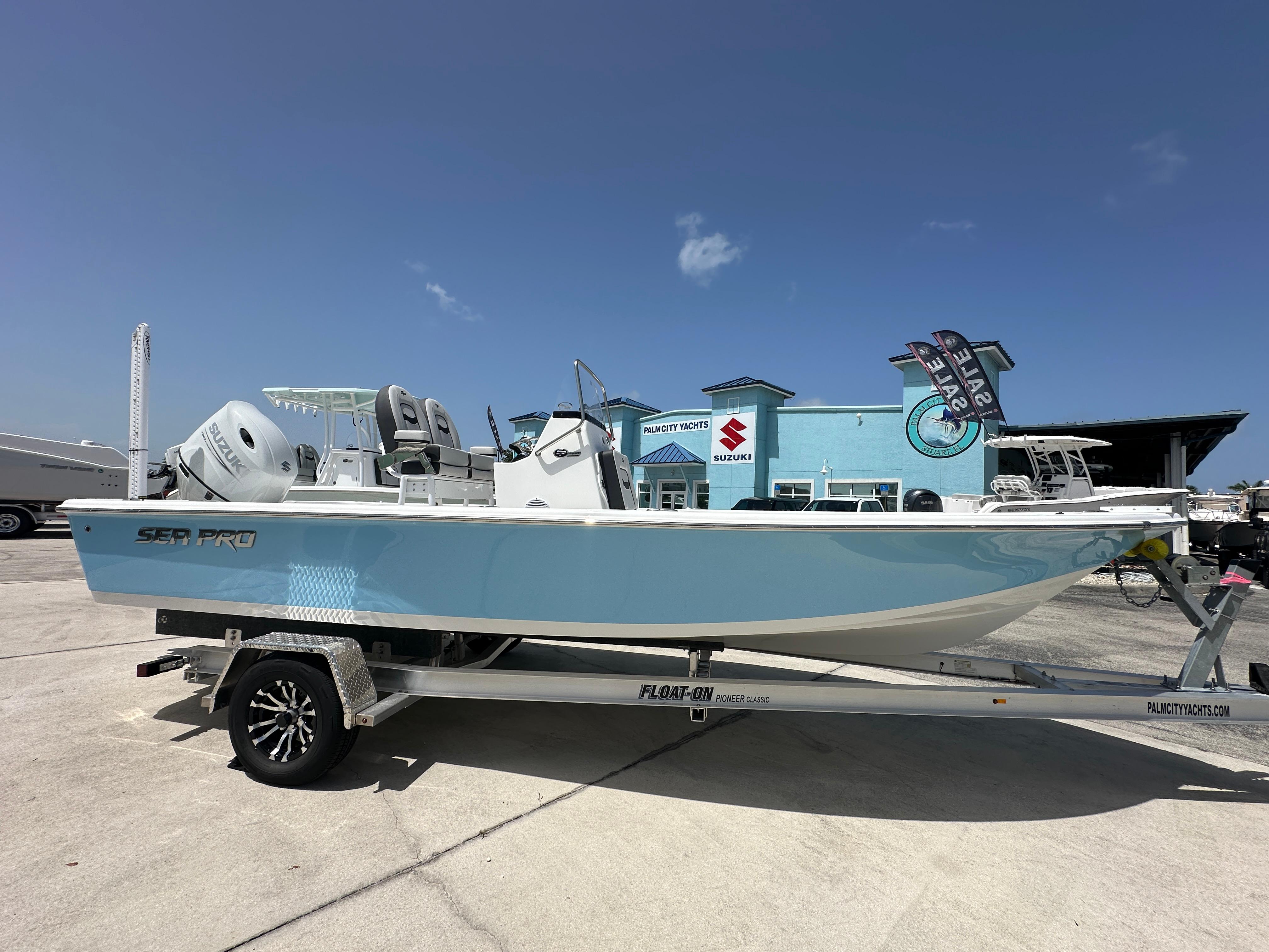 Sea Pro 230 Bay 2026 Sea Pro 230 Bay boat on trailer, displayed at dealership under clear blue sky.