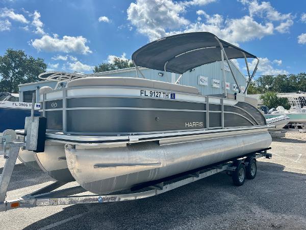 Harris Cruiser 230 2023 Harris Cruiser 230 pontoon boat on trailer under a sunny sky.