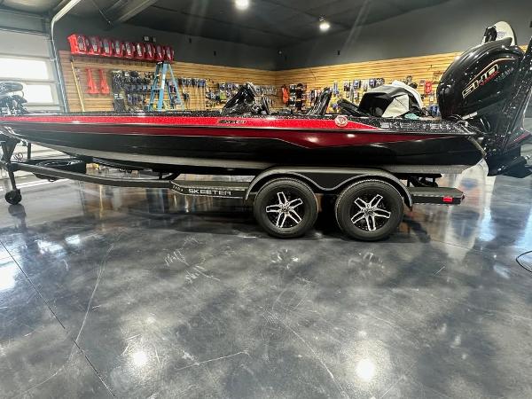 Skeeter ZXR 21 2025 Skeeter ZXR 21 boat in showroom, black and red design, on trailer.