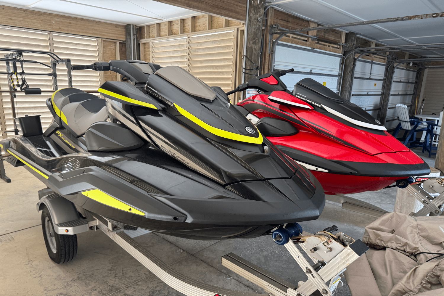 Yamaha Boats FX1800B-YB 2023 Yamaha FX1800B-YB jet skis in black and red on trailers in a garage.