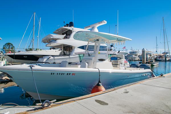 Cobia 240 CC 2018 Cobia 240 CC boat docked at a marina under clear blue skies.
