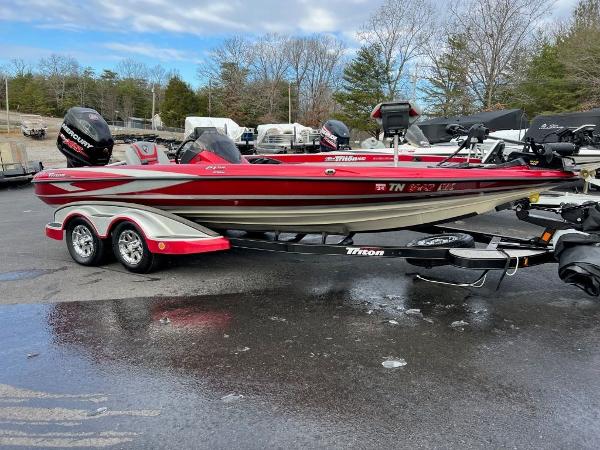 Triton 21 TRX 2016 Triton 21 TrX bass boat on trailer, red and white, parked outdoors.
