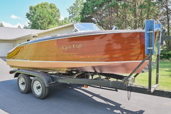 Chris-Craft 17 1942 Chris-Craft 17 wooden boat on a trailer in a driveway.