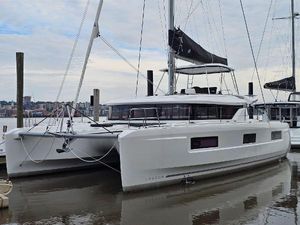 Lagoon 46 2024 Lagoon 46 catamaran docked at marina, showcasing sleek design and modern features.