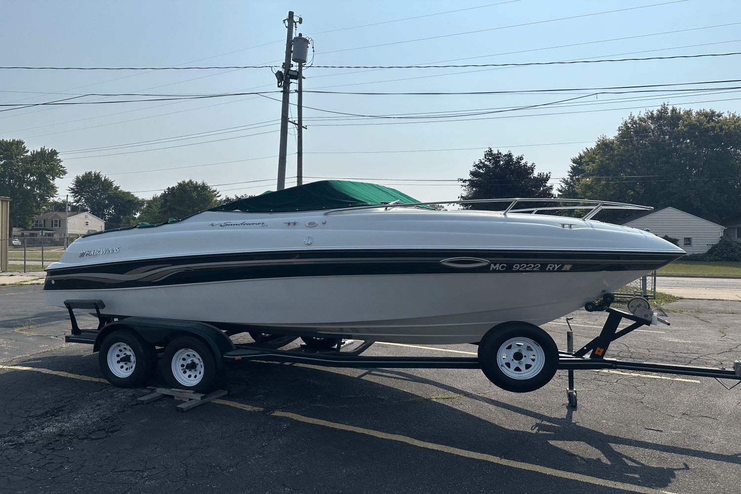 Four Winns Sundowner 225 1999 Four Winns Sundowner 225 boat on trailer, parked outdoors.