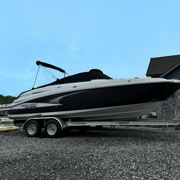 Monterey M4 2024 Monterey M4 boat on trailer, parked outdoors under clear sky.