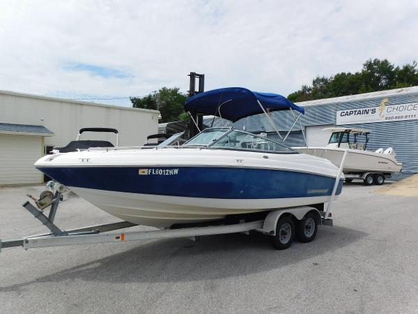 Chaparral 204 SSi 2008 Chaparral 204 SSi boat on trailer with blue canopy in parking lot.