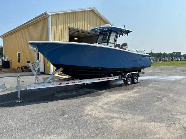 Sportsman 262 Open 2025 Sportsman 262 Open boat on trailer outside yellow building.