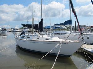 Sabre 34 1987 Sabre 34 sailboat docked in a marina under a partly cloudy sky.