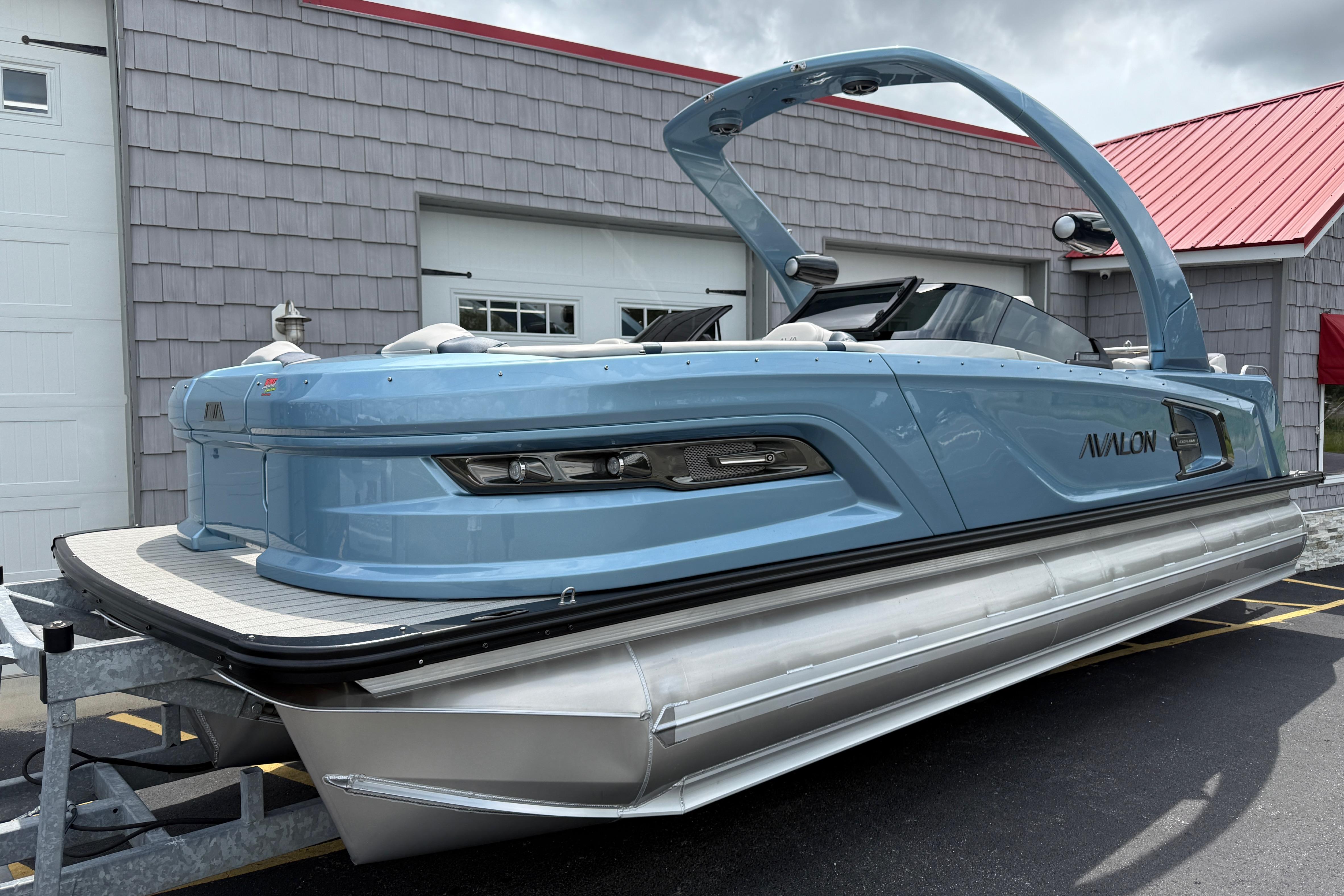 Avalon 2585 Excalibur Windshield Quad Lounger Shift, Tri toon, Mercury 400hp V-10 2026 Avalon 2585 Excalibur Tri-toon boat with Mercury 400hp V-10 engine, parked outdoors.
