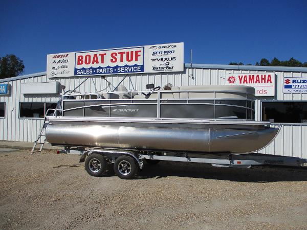 Starcraft LX 20 CB 2025 Starcraft LX 20 CB pontoon boat on trailer outside dealership.