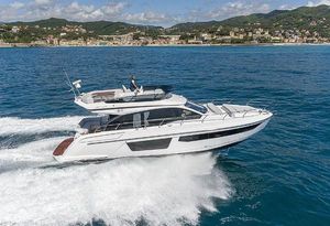 Azimut Fly 53 2023 Azimut Fly 53 yacht cruising on blue ocean near scenic coastline.