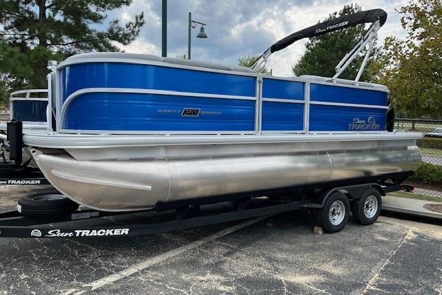 Sun Tracker Party Barge 20 DLX 2026 Sun Tracker Party Barge 20 DLX pontoon boat on trailer, blue and silver design.