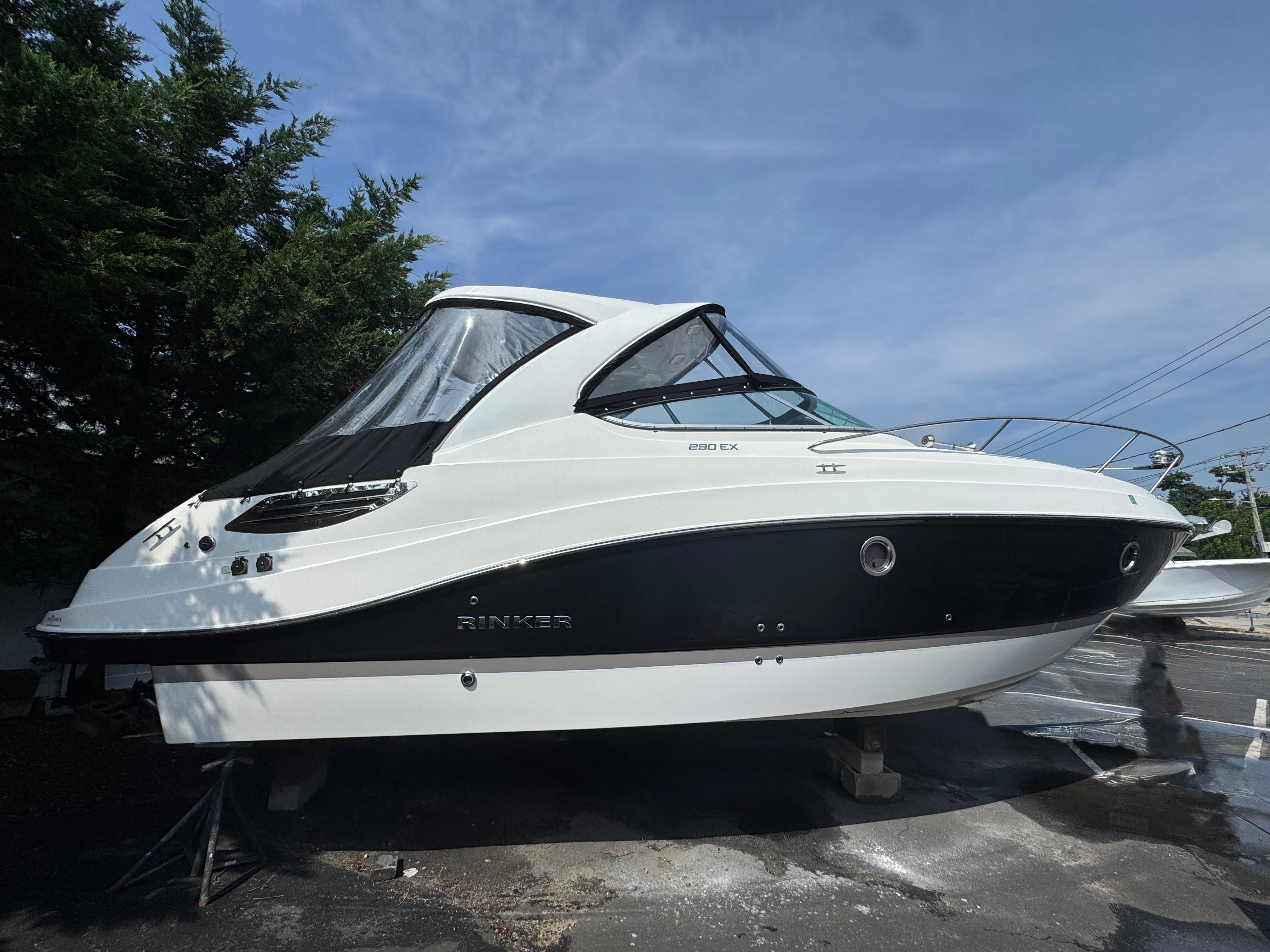 Rinker 290 Express Cruiser 2020 Rinker 290 Express Cruiser boat on display, side view under clear sky.