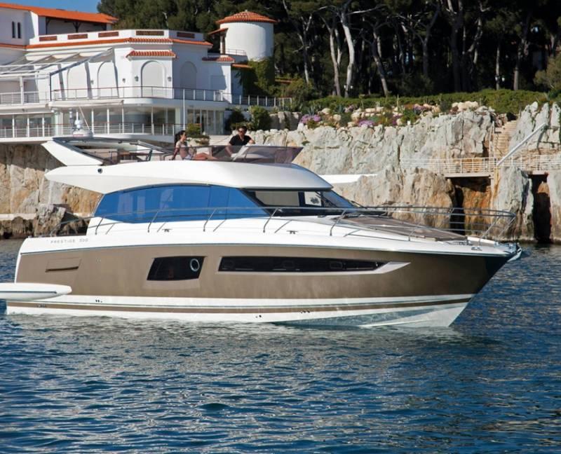 Prestige 500 2012 Prestige 500 yacht cruising near rocky coastline and luxury villa.