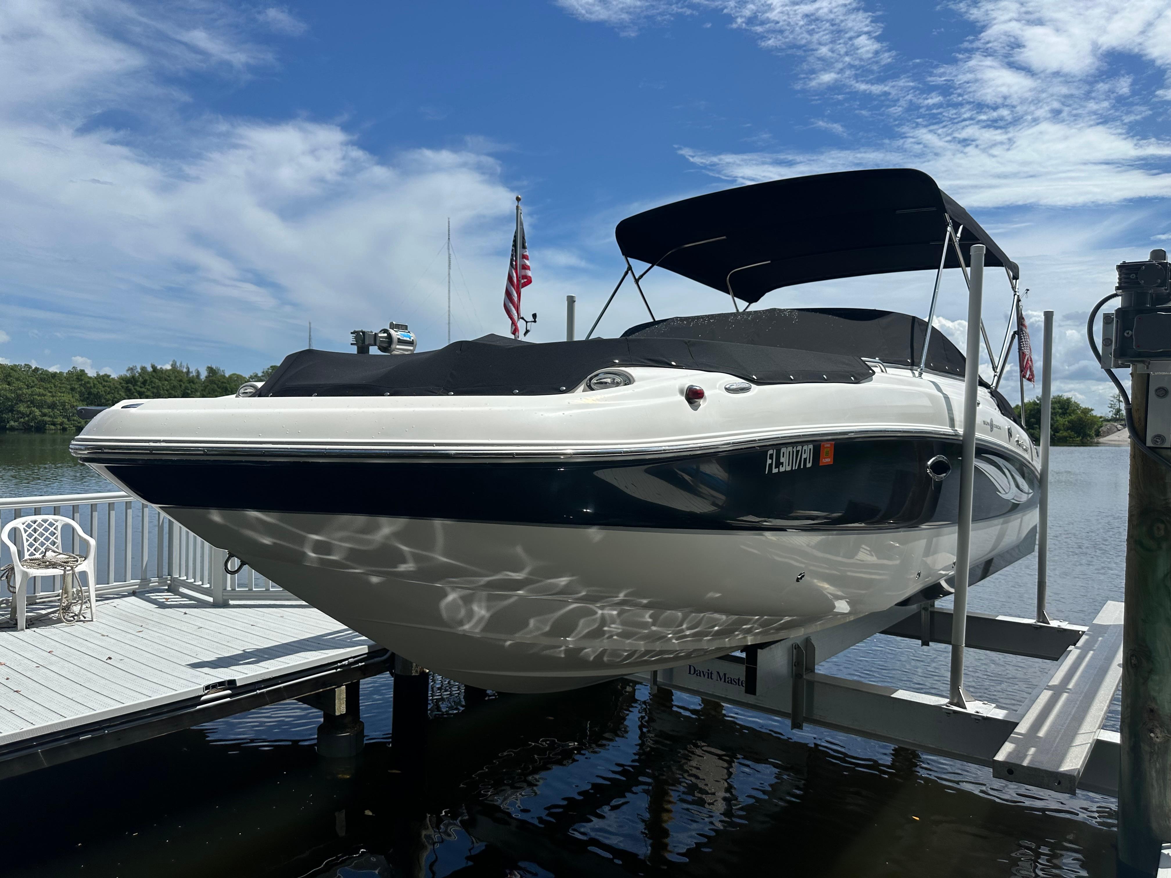 Hurricane 2400 SunDeck OB 2011 Sea Ray 240 Sundeck boat docked, featuring a sleek design and black canopy.