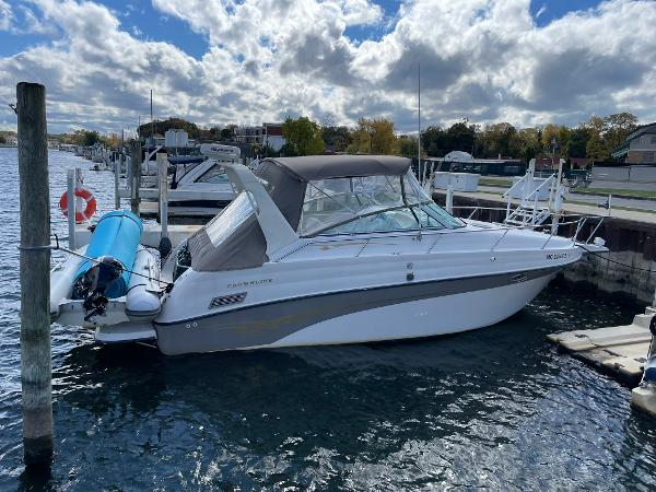 Crownline 290 CR 2000 Crownline 290 CR boat docked at marina under cloudy sky.