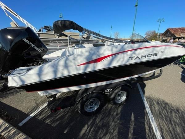 Tahoe 2150 2024 Tahoe 2150 boat on trailer, parked outdoors, featuring sleek design and Mercury engine.