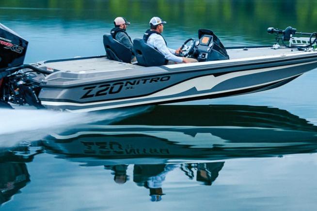 Nitro Z20 XL PRO 2026 Nitro Z20 XL PRO boat speeding on calm water with two passengers.